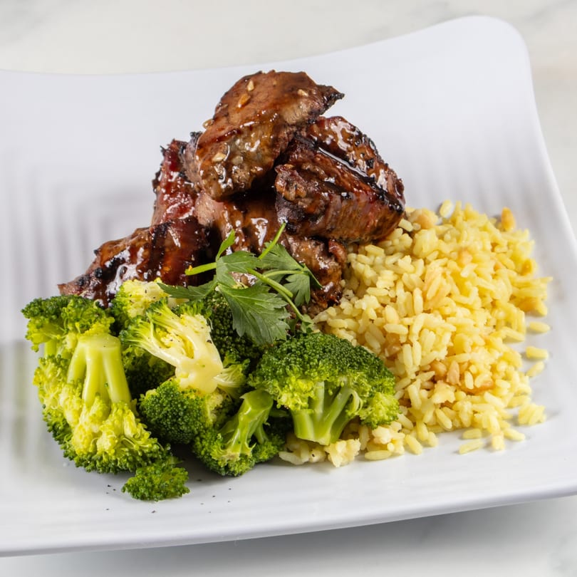 North End Market & Deli's teriyaki steak, yellow rice, and steamed broccoli on a white plate.