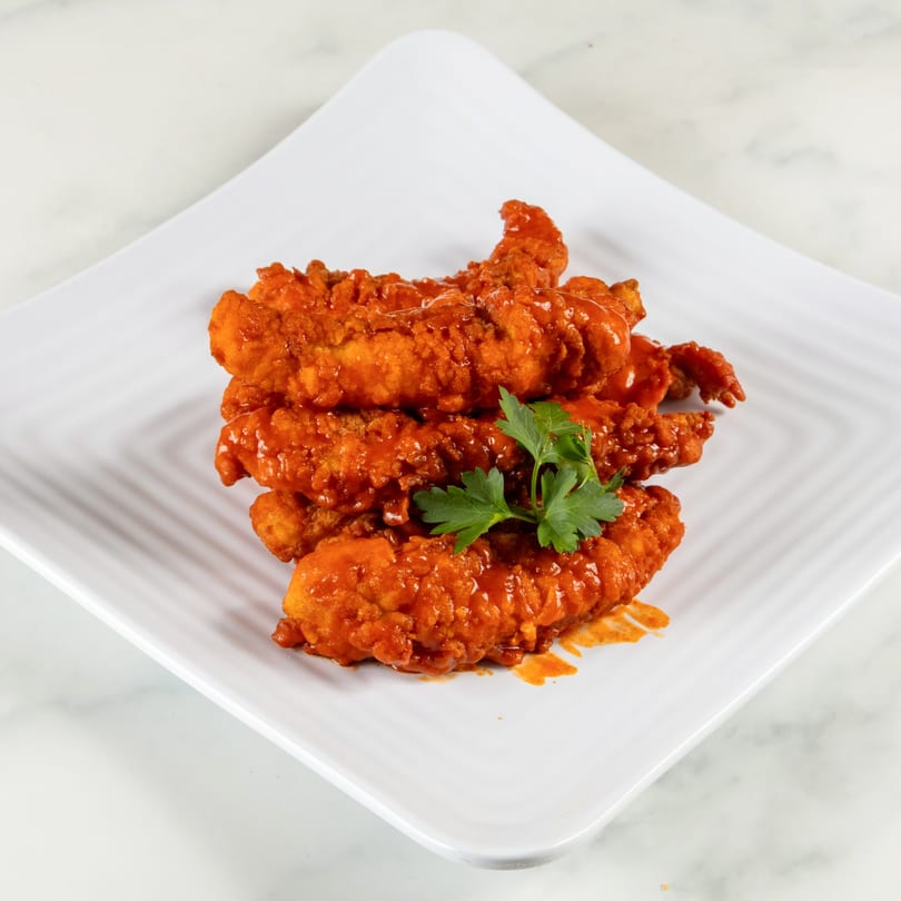 North End Market & Deli's buffalo chicken tenders, garnished with parsley, on a white plate.